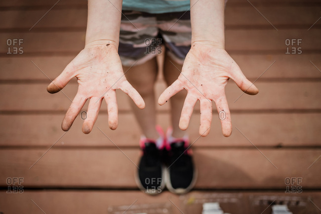 Girl showing her dirty hands while gardening