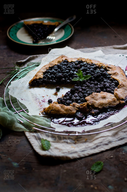 Messy aronia berry wholewheat galette decorated with fresh mint