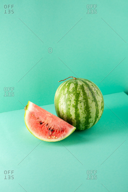 Whole Watermelon and slice on green background