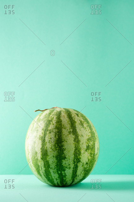 Whole Watermelon sitting on turquoise table