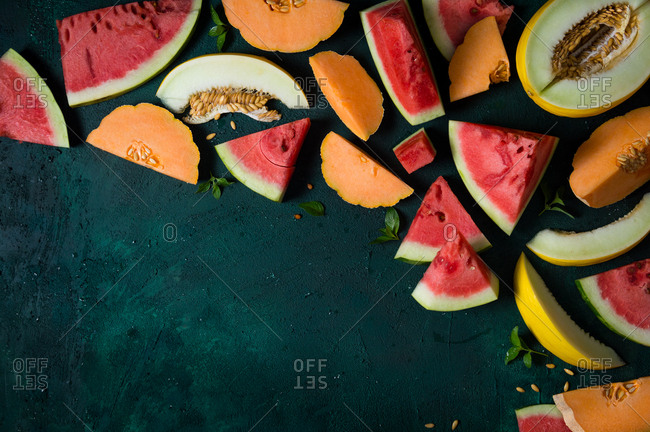 Slices of watermelon, cantaloupe and canary melon with fresh mint