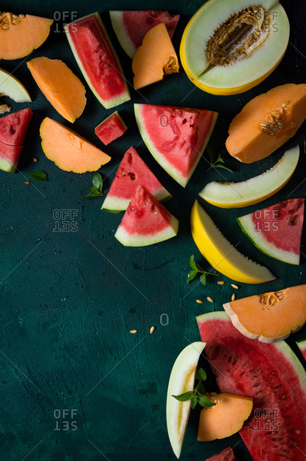 Slices of watermelon, cantaloupe and canary melon with fresh mint