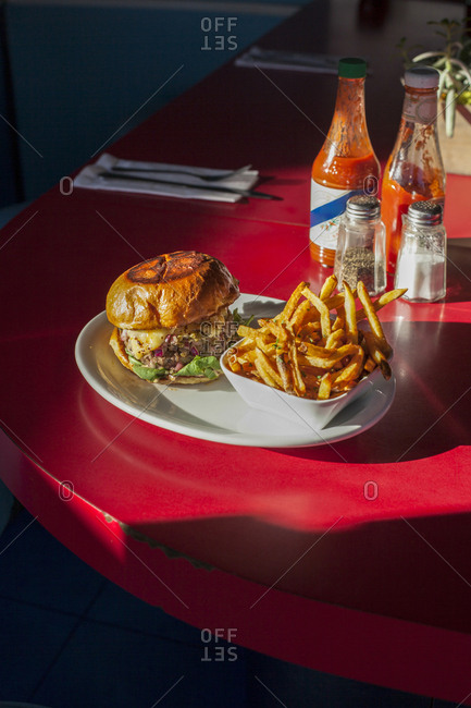 High angle view of burger with French fries served in plate on table at restaurant