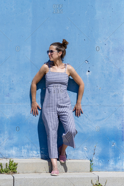 Portrait of confident female leaning on wall outdoors, looking away