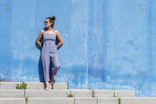 Portrait of confident female leaning on wall outdoors, looking away