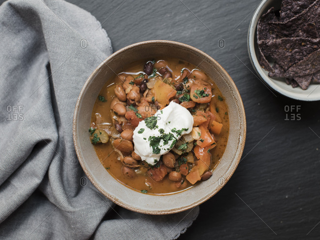 High angle view of curry with chips served in bowls and napkin on table