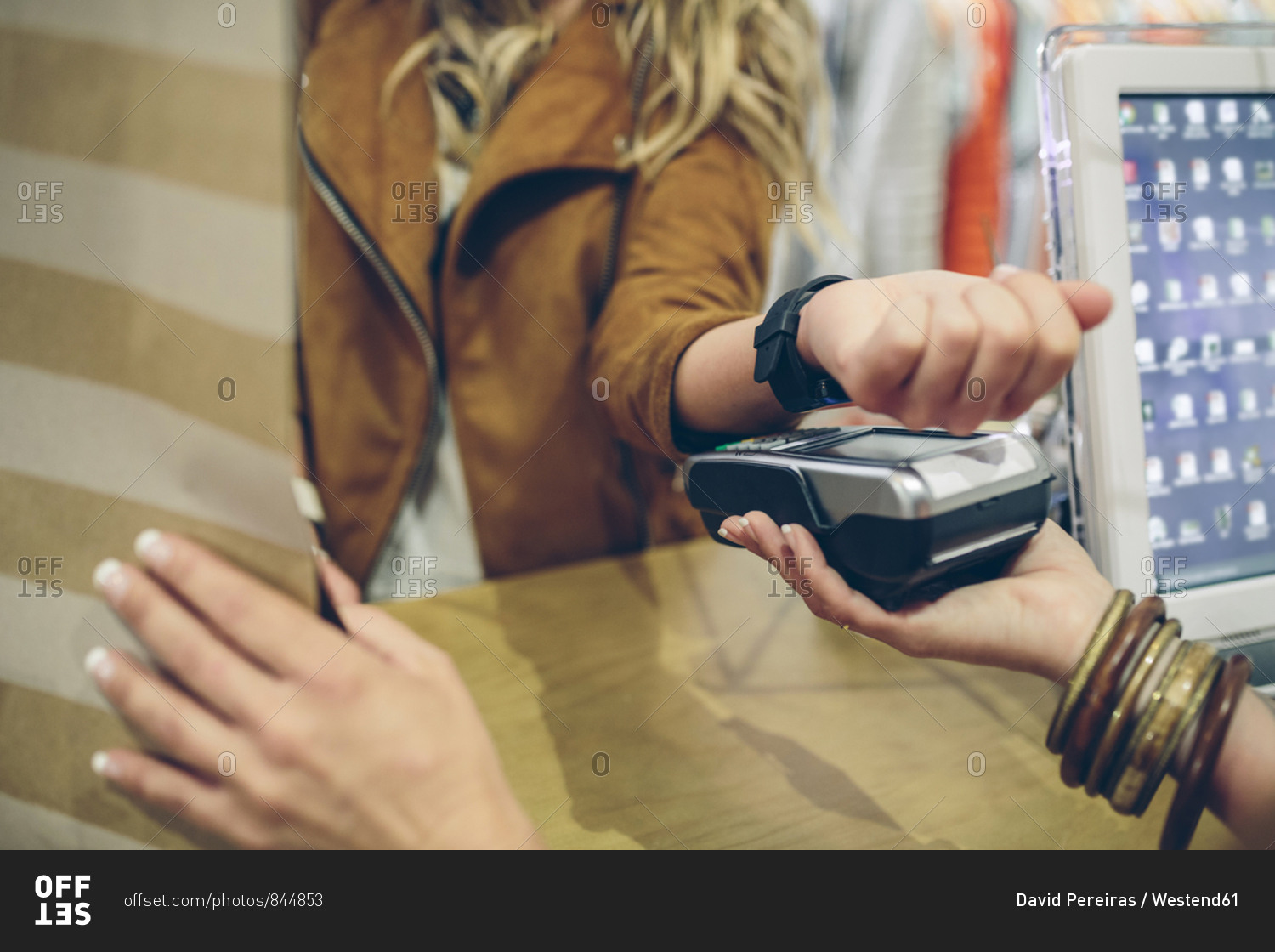 Woman paying using smartwatch with NFC technology in a store
