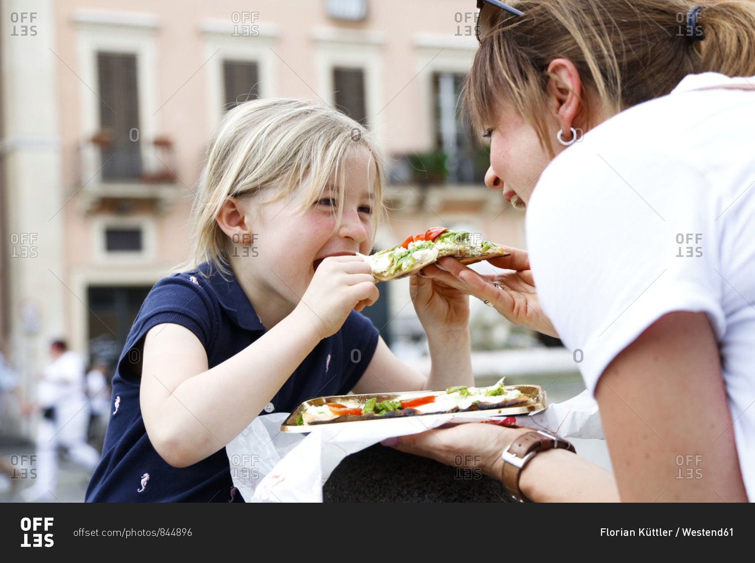 Italy- mother and little daughter eating Pizza together