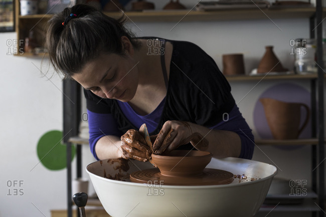 Potter forming clay on a wheel