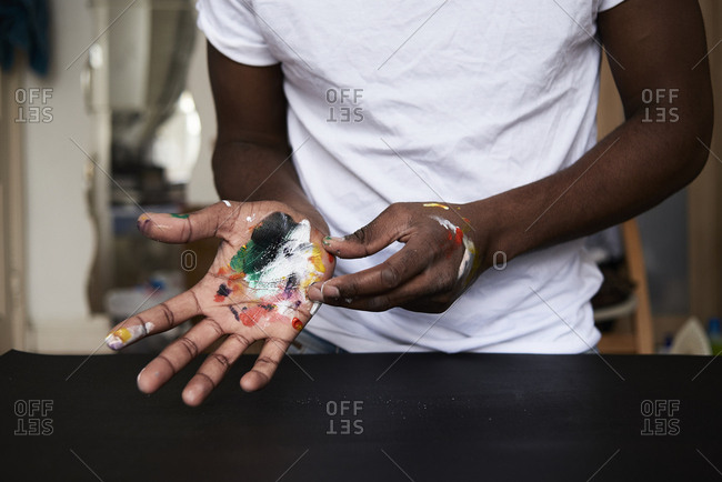 Dirty hands of artist with colorful paints- close up