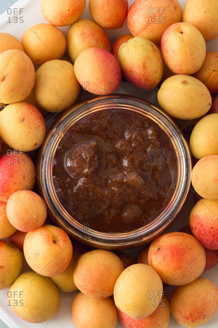 Glass of apricots jam and apricots close up