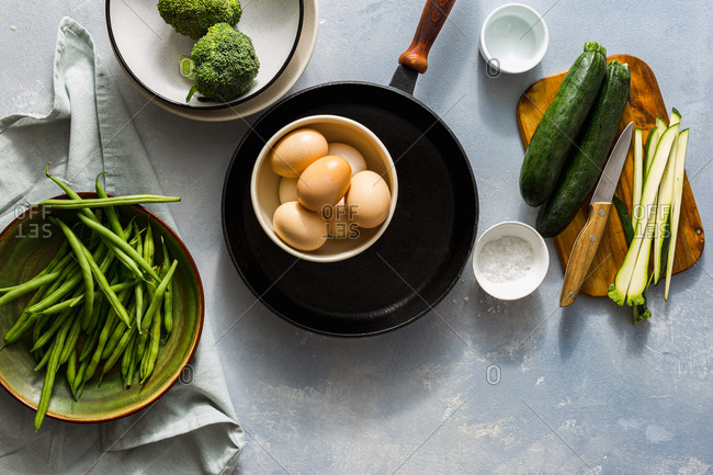Overhead view ingredients for making fried eggs with vegetables
