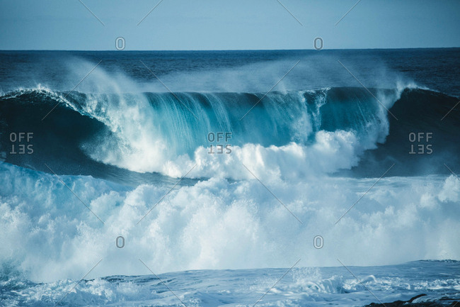 Scenic view of a big wave breaking in the sea against clear sky
