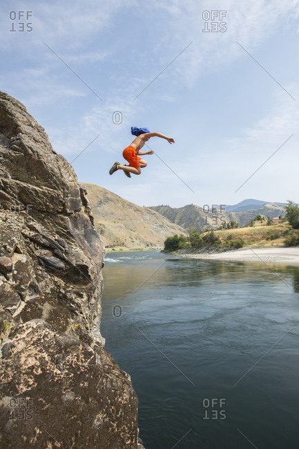 Boy, age 11 jumping off a large cliff into the Salmon River, Idaho.