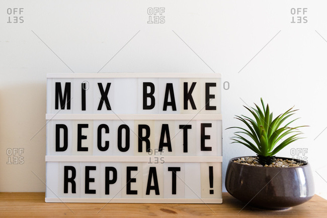 A baking sign saying 'mix, bake, decorate, repeat!'