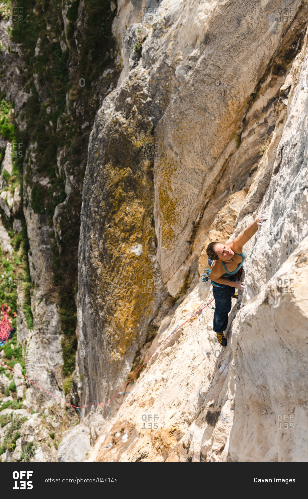 Strong woman rock climber grabbing a ledge in overhanging wall