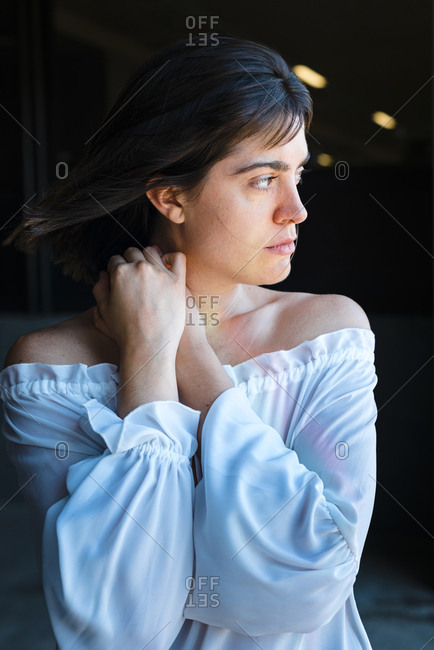 Passionate young brunette woman looking away with hair blowing in the wind