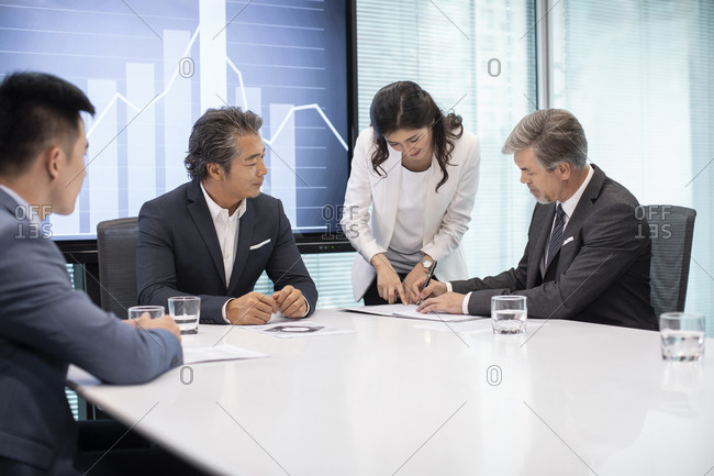 Business people signing contract in conference room