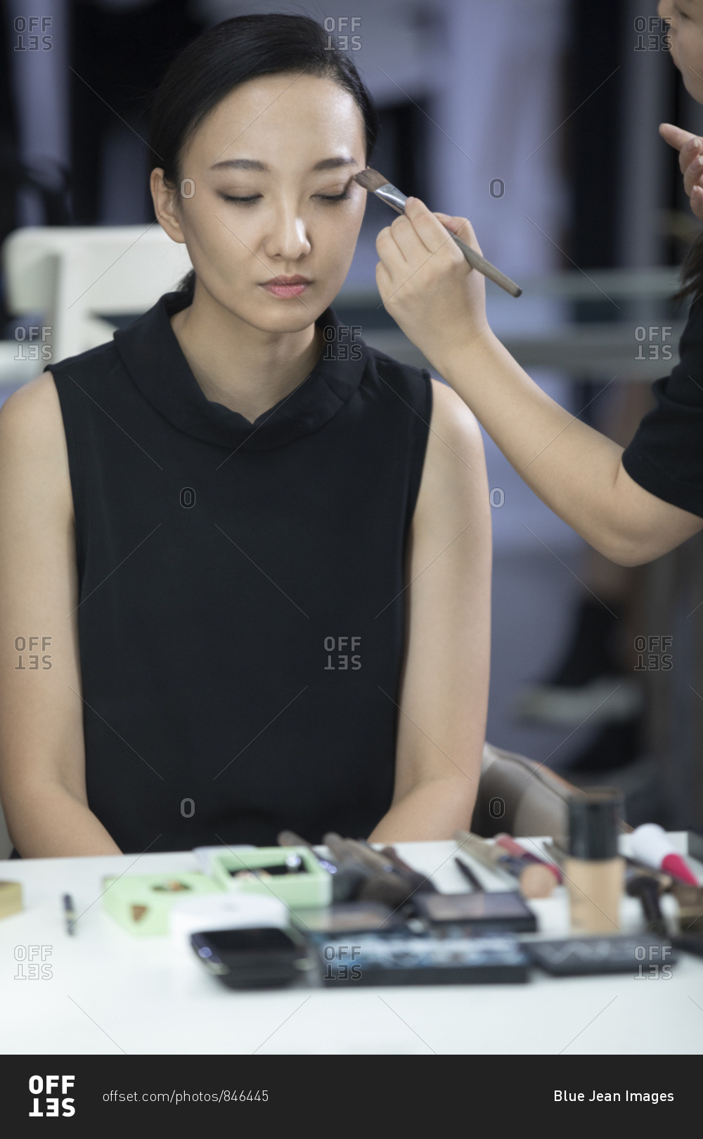 Chinese makeup artist applying makeup on model