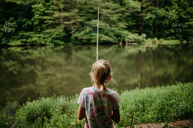 Rear view of little girl fishing in a lake