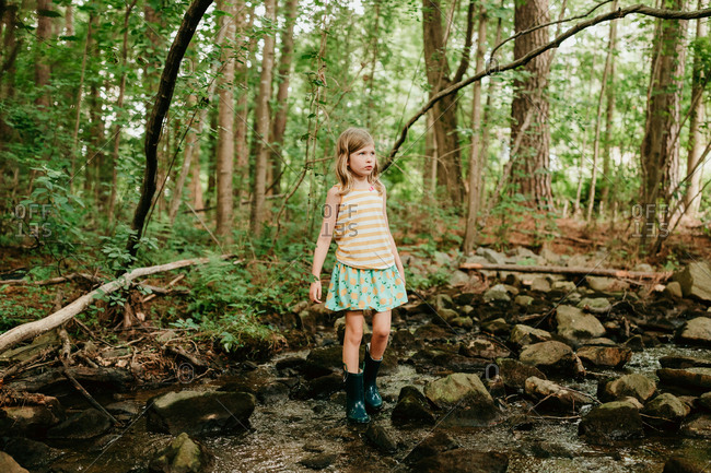 Little blond girl walking in creek