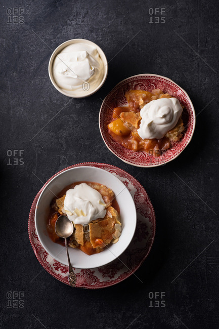 Peach cobbler with hot sugar crust and whipped cream