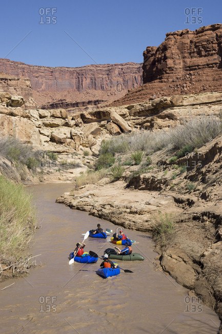 A group of women pack rafting on a desert river.