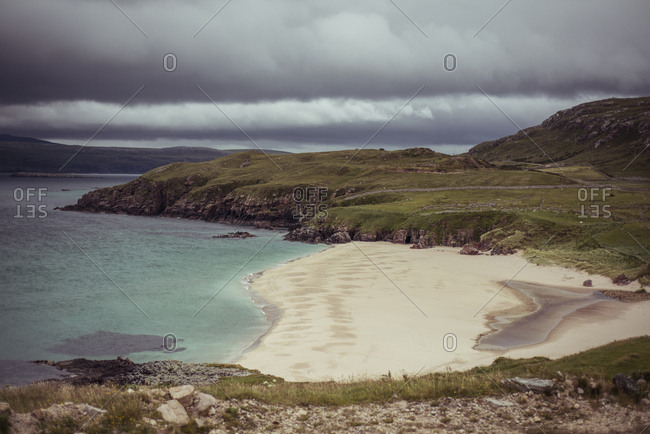 View over empty pristine beach with cliffs and white sands