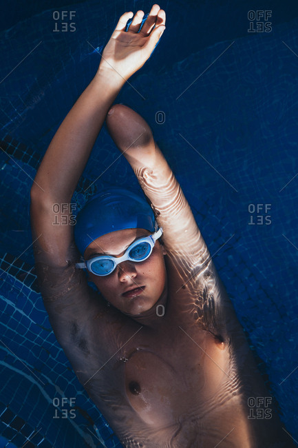 Portrait of paralympic young swimmer floating on water in a pool