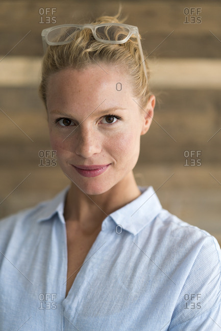 Portrait of blond woman- glasses- wooden background