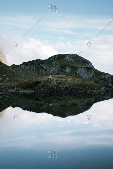 Calm water lake mirror reflection of the mountains on a foggy day