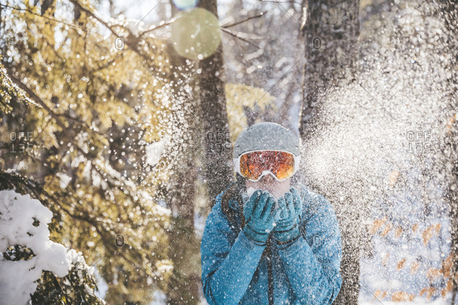 Woman in ski goggles and helmet in backlit snow scene in New Hampshire