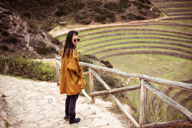 Person in jacket and glasses at archaeological Inca ruins site
