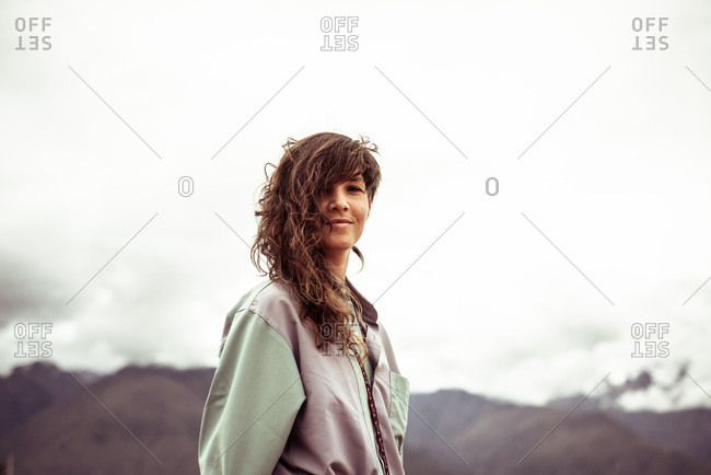 Girl with curly wild hair and shirt smiles at camera