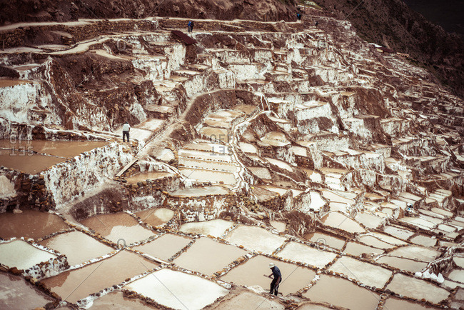 Men work in salt farms on mountain side in Maras