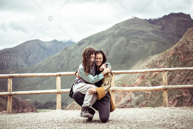 lesbian couple laugh and hold each other in travel selfie