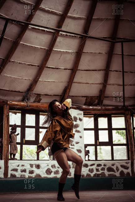 Mixed race fashionable dancer dances in stone  and straw dome studio