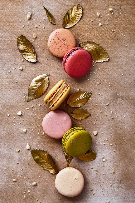 Macarons with golden leaves on a golden sprayed background