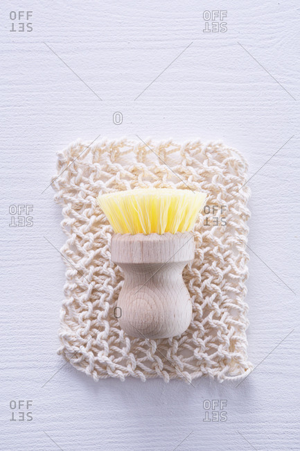 Ecologically friendly brush on cleaning rag against white table