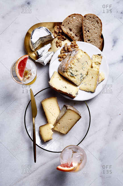 Assortment of cheese and drinks on a marble counter top