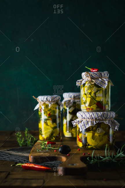 Marinated goat cheese with fresh herbs, spices and chili peppers in olive oil