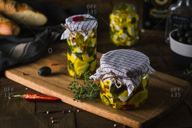Marinated goat cheese with fresh herbs, spices and chili peppers in olive oil