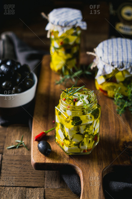 Marinated goat cheese with fresh herbs, spices and chili peppers in olive oil