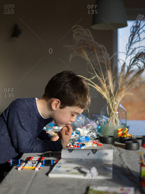 Young boy concentrating while building with a toy building blocks