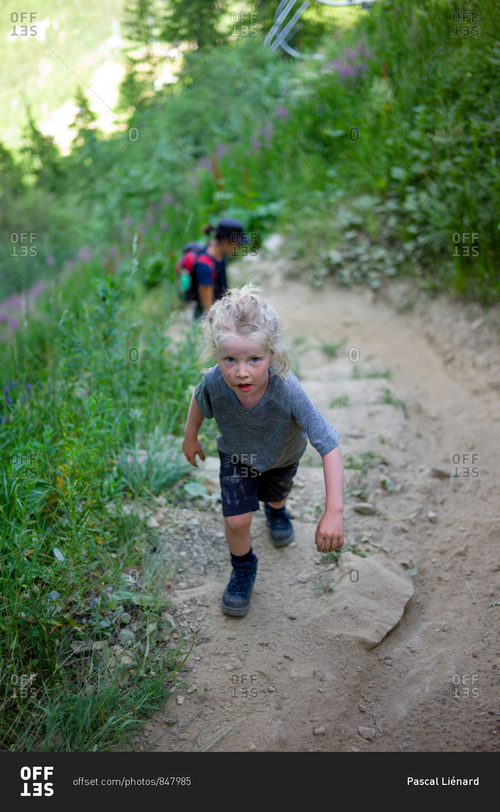 Little girl walking up a steep path covered in dirt during a hike in