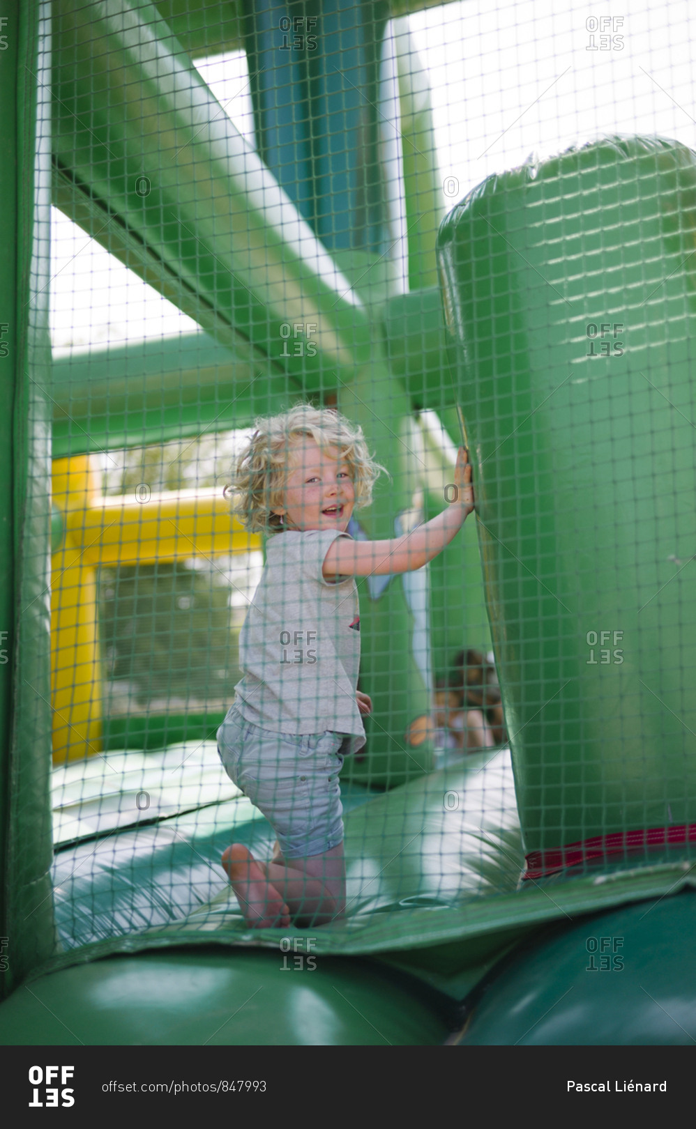 Little girl having fun in colorful green and yellow inflatable games