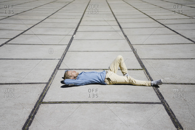 Young man lying on a square