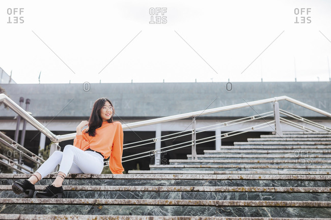 Asian woman sitting on steps