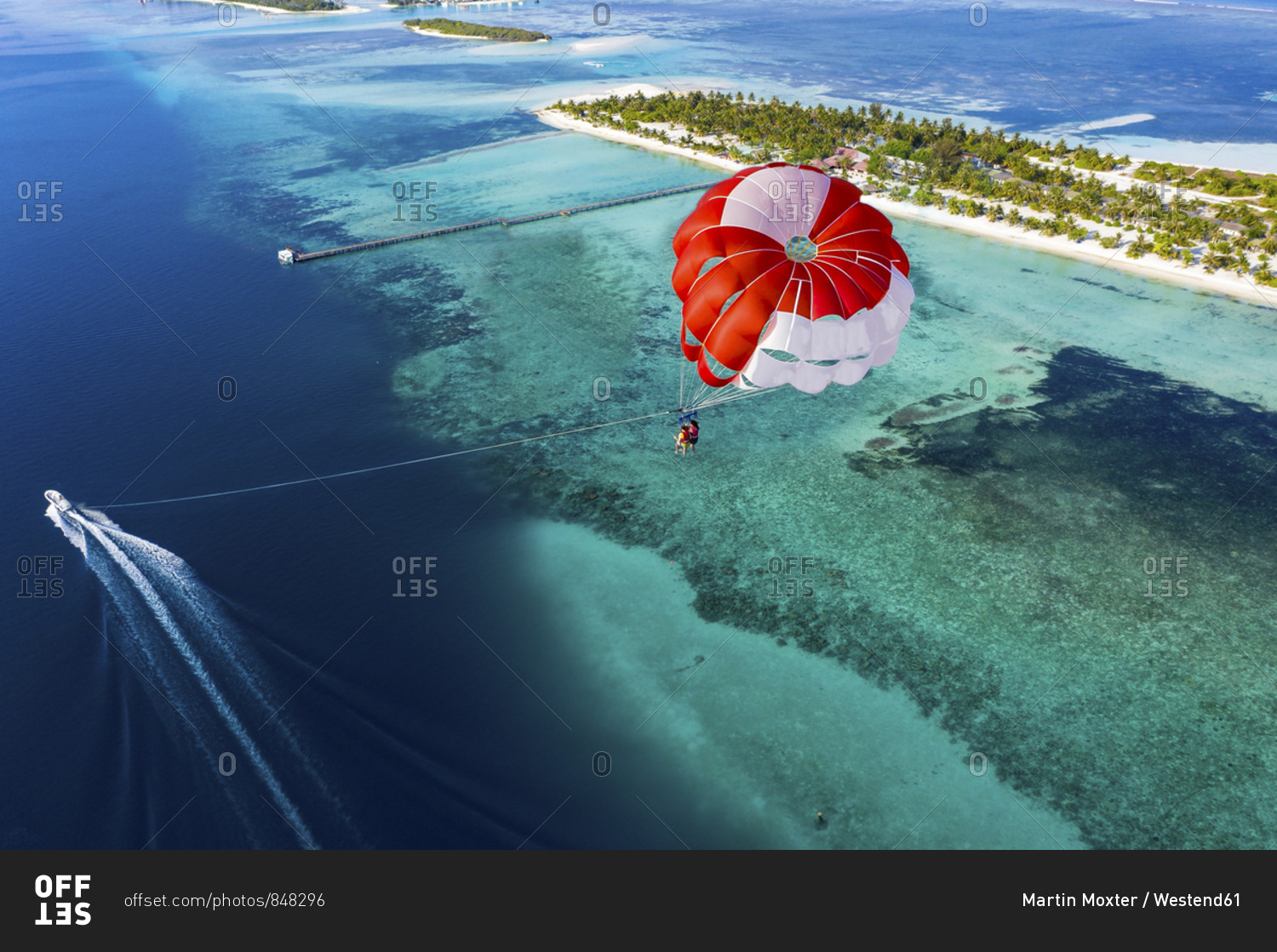 Aerial view of a paraglider flying along an atoll- South Male Atoll- Maldives