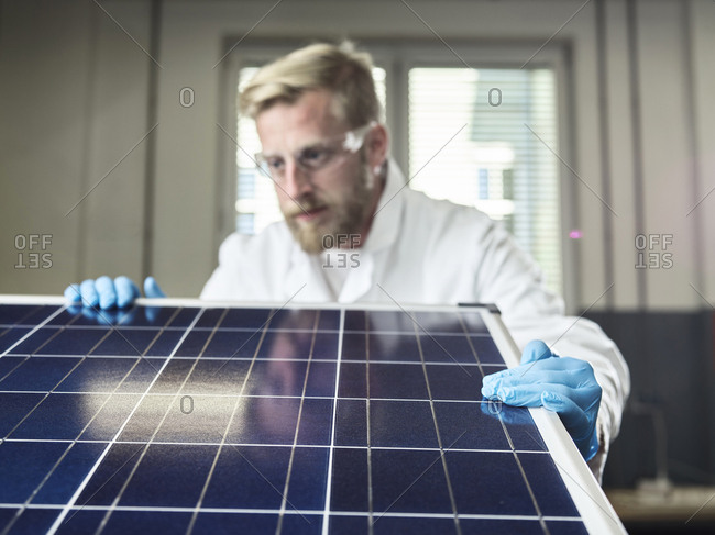 Technician controlling solar panel in lab
